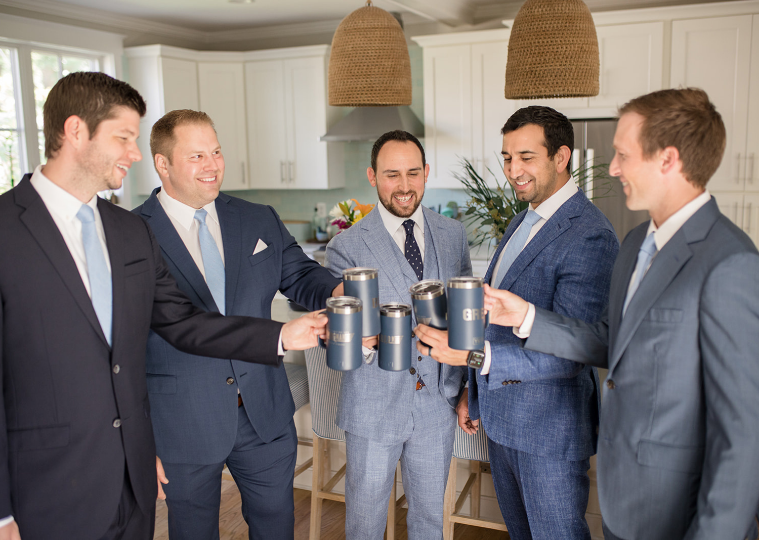 groom and groomsmen sharing a drink and a toast before the wedding