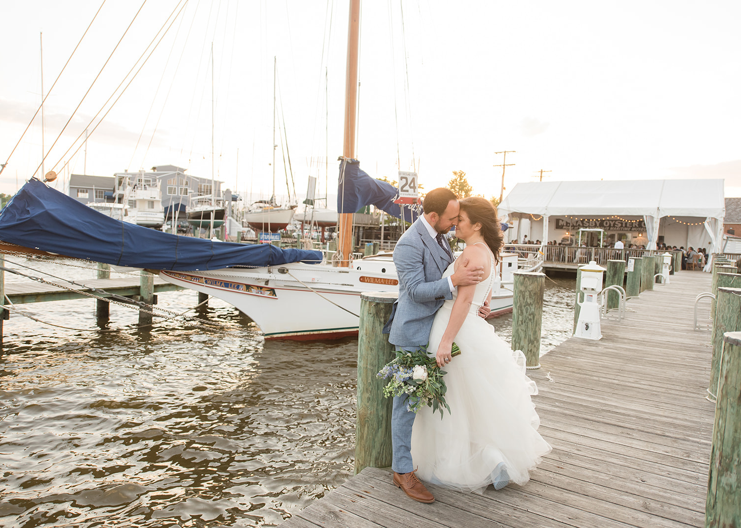 bride and groom share a kiss in the pier in the annapolis maritime museum