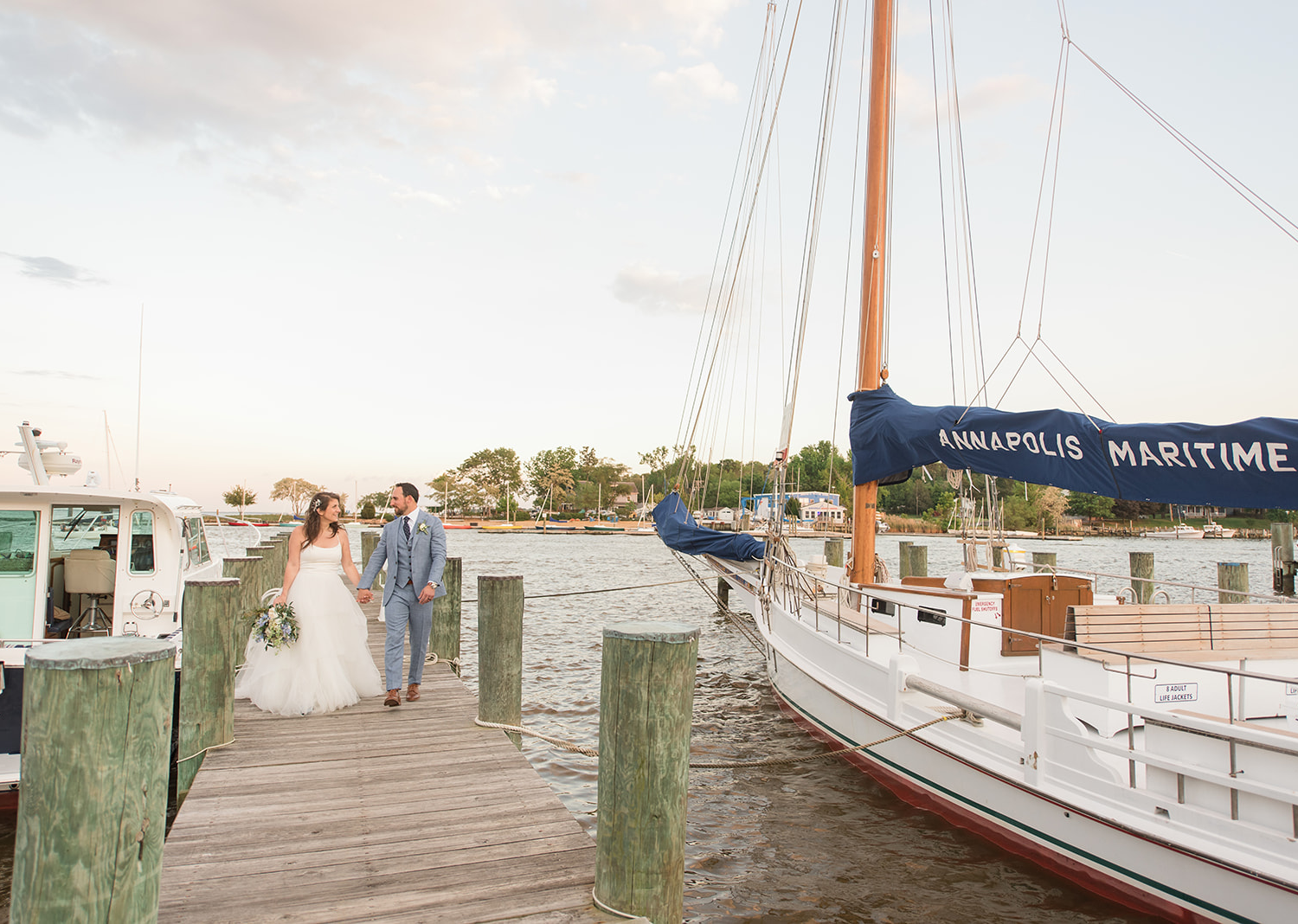 bride and groom walk down the pier 