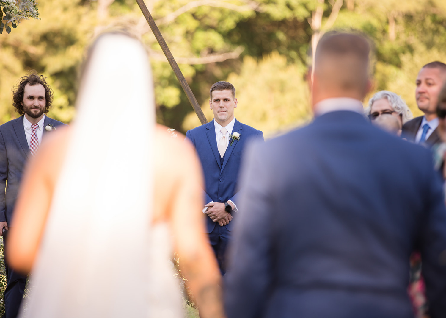 groom watching his bride walk down the aisle 