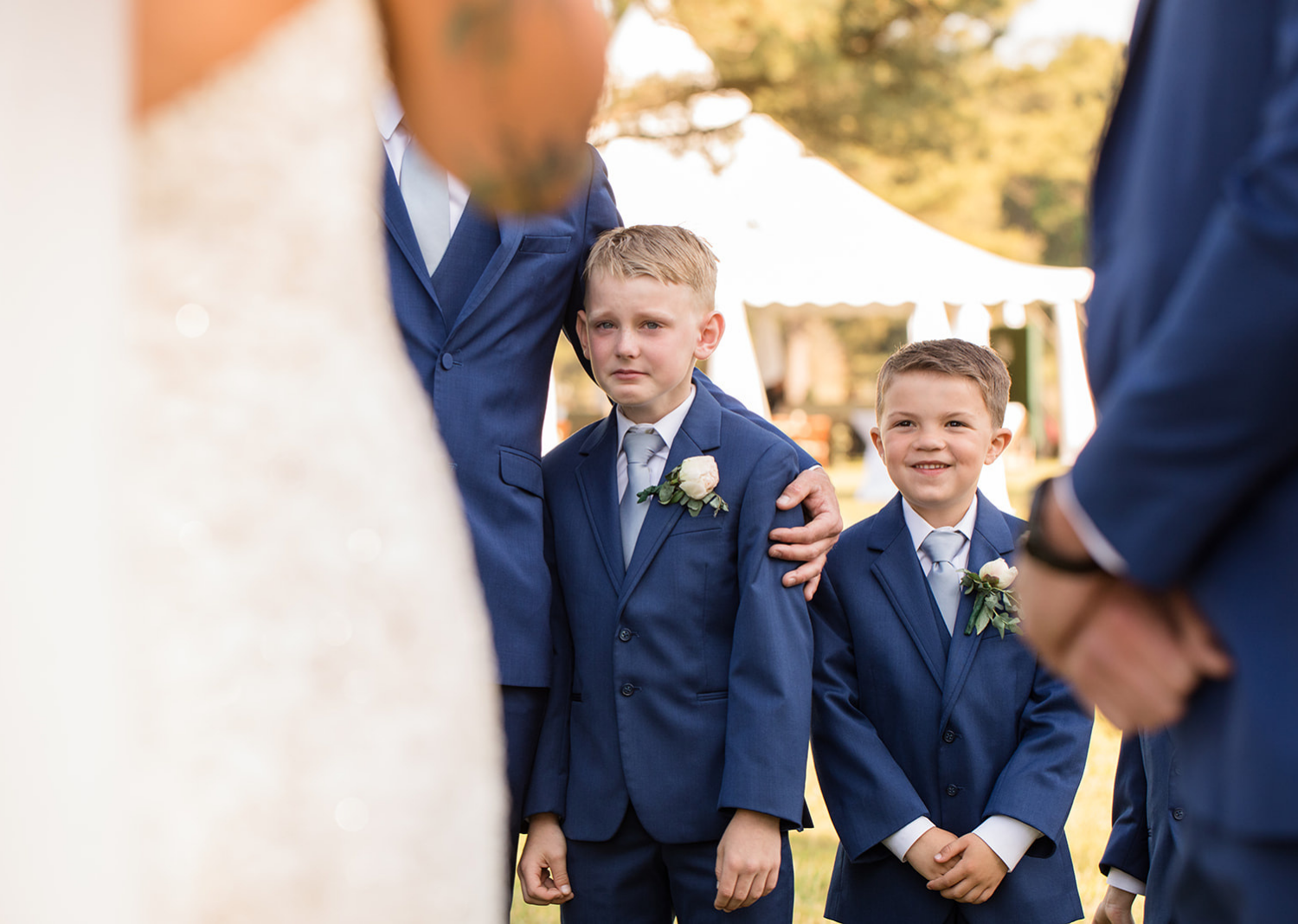 little groomsmen and kids of the bride and groom cry as he hears his aprents read their wedding vows 