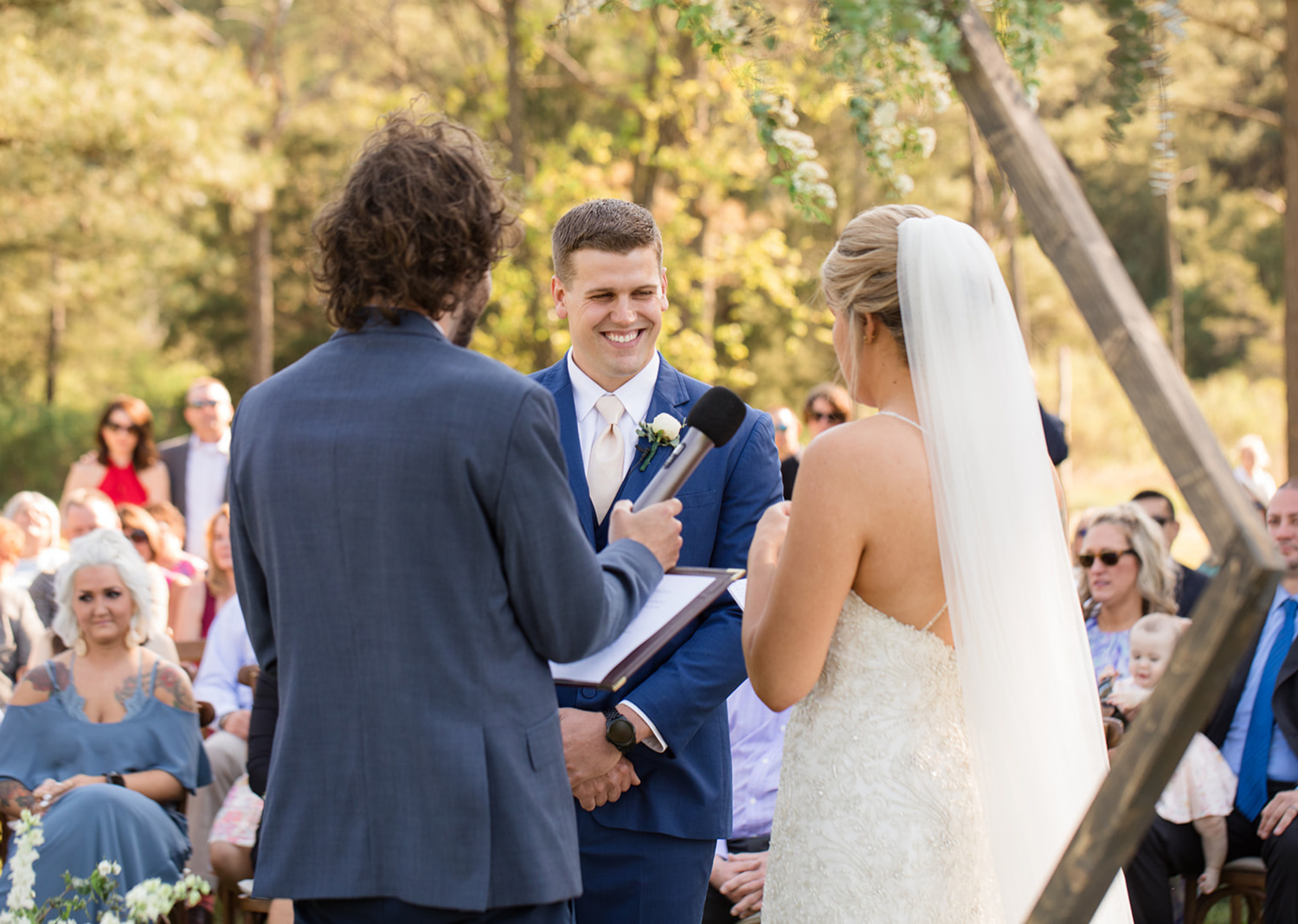 groom smiling as bride reads her wedding vows