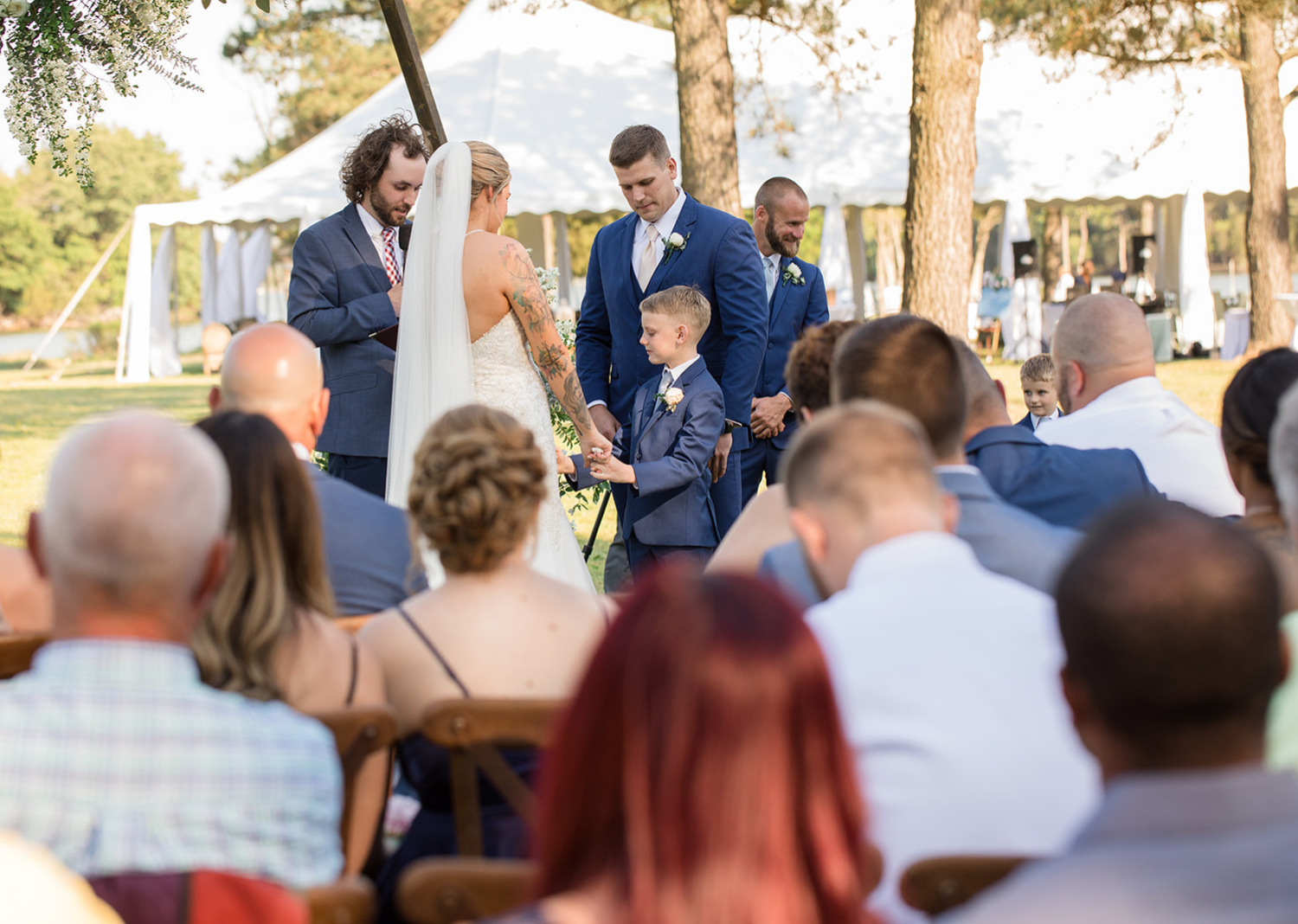 little groomsmen gives bride and groom their wedding rings as a ring bearer