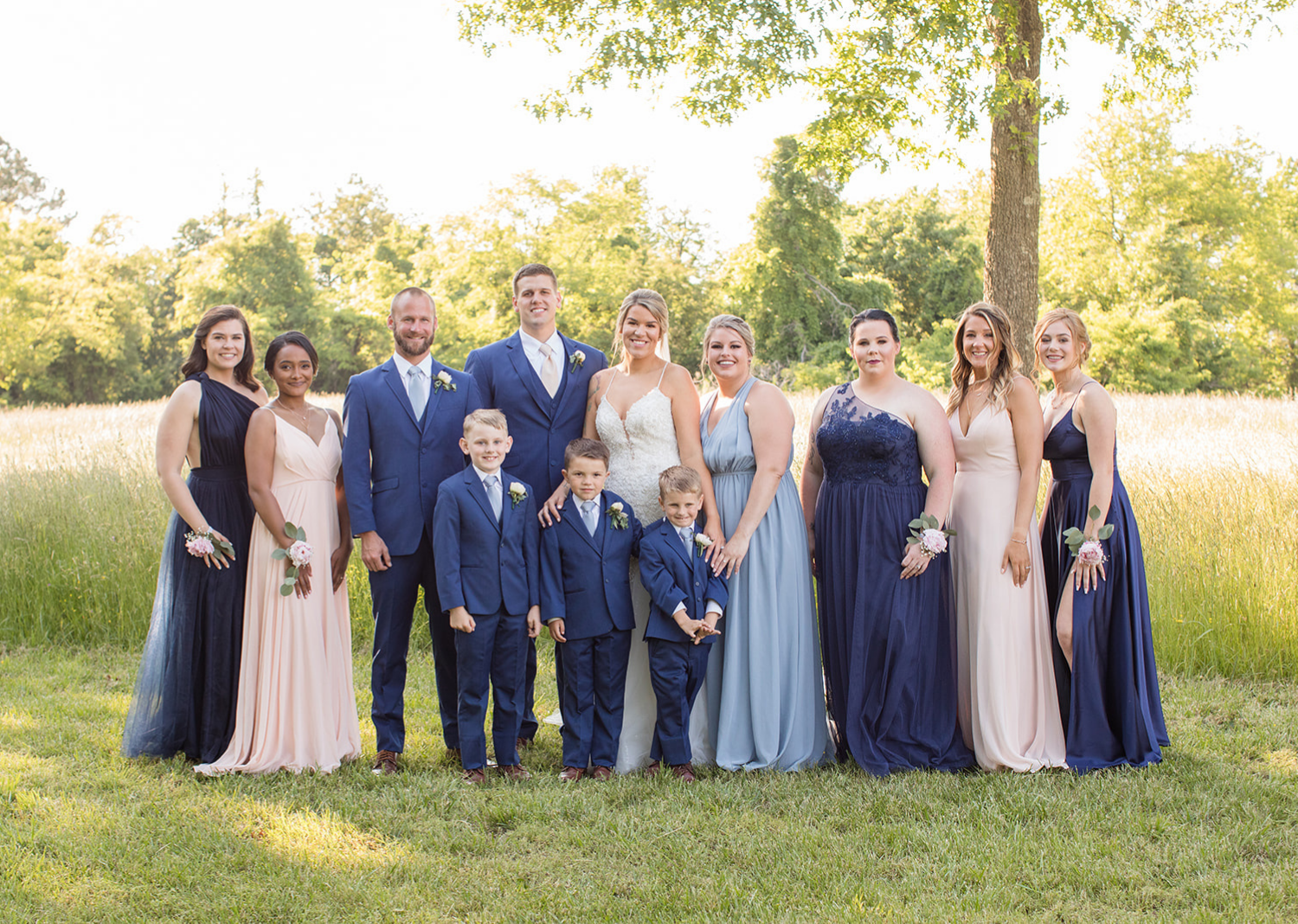 bridal party stand around the bride and groom