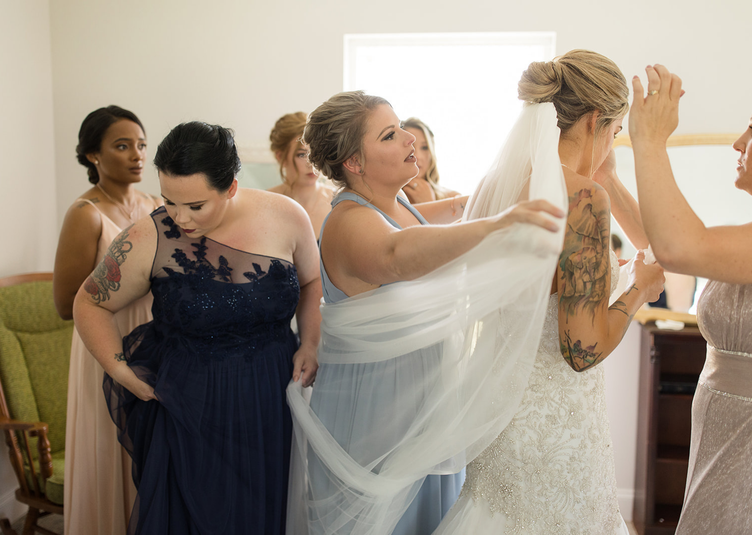 bridal party helping the bride put on her wedding veil