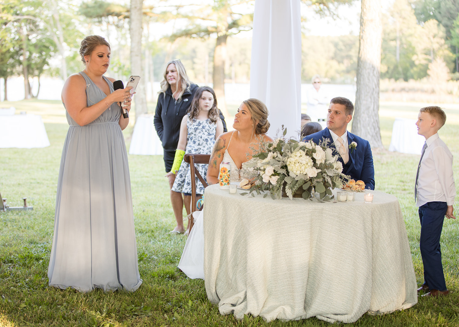 bride and groom listening to the maid of honors wedding speech