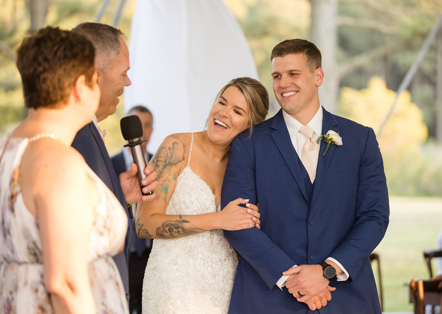 bride and groom smiling as they hear their family giving speeches