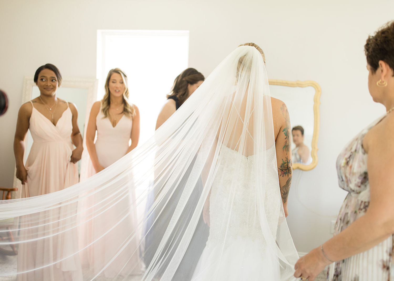 bridal party looking at the bride as she is finally fully ready 