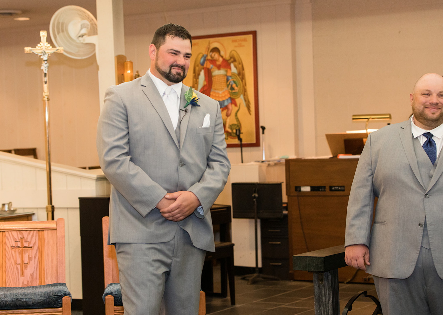 groom watches bride walk down the aisle