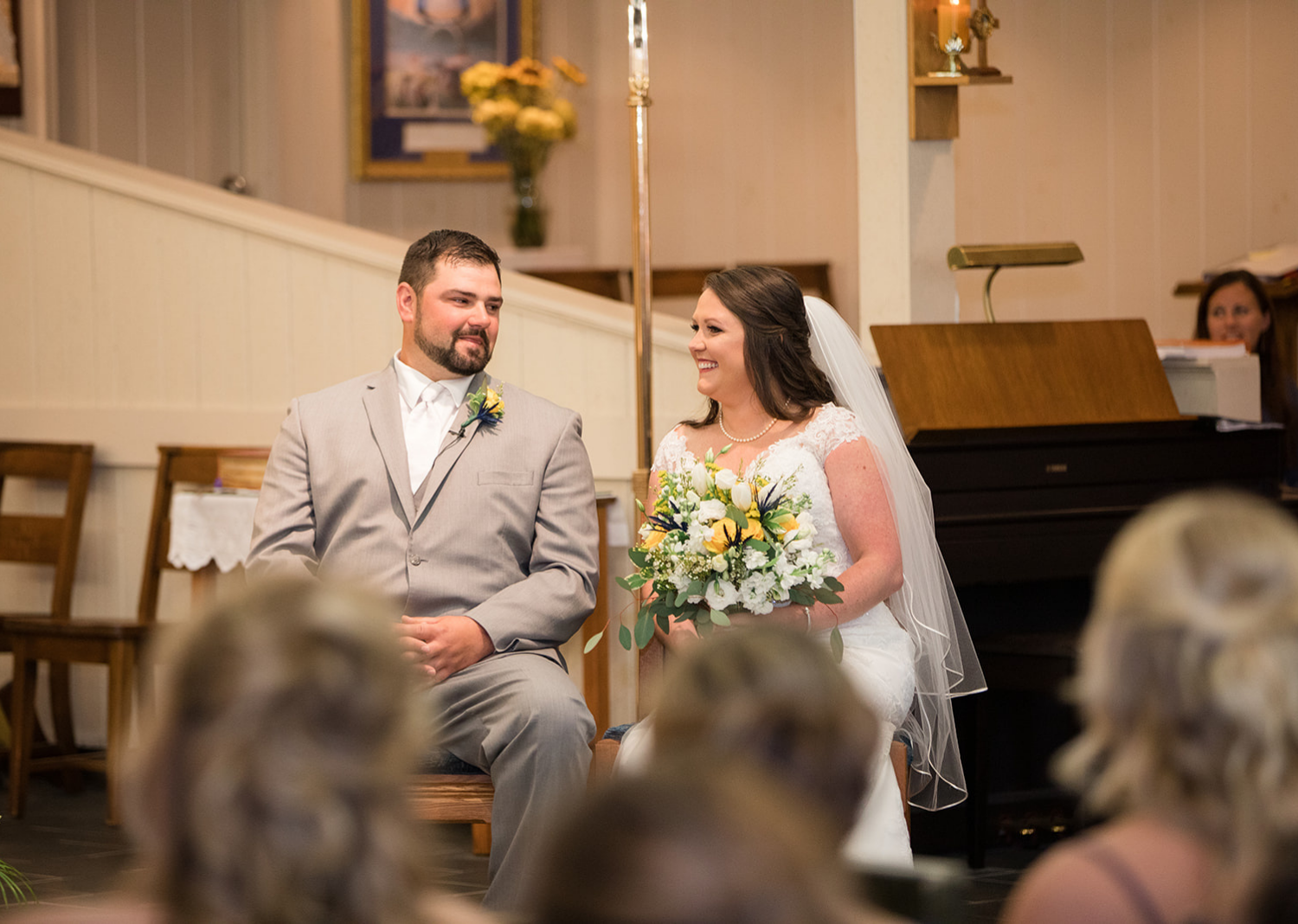 groom and bride smiling as they hear their wedding talk