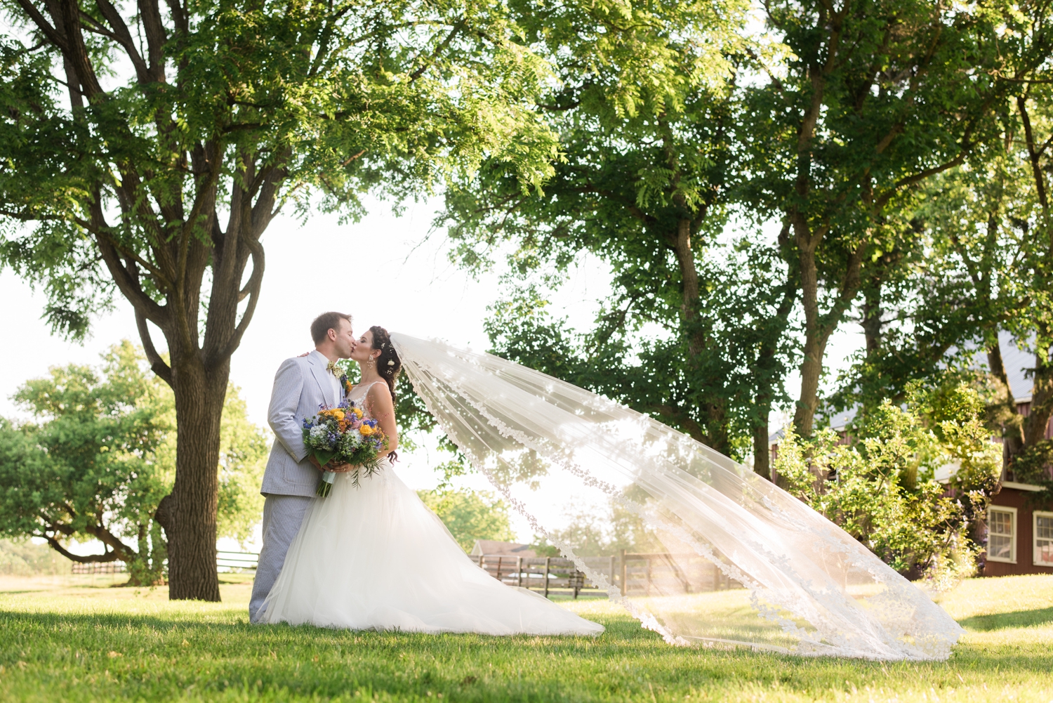 bride and groom kiss with wind-swept veil