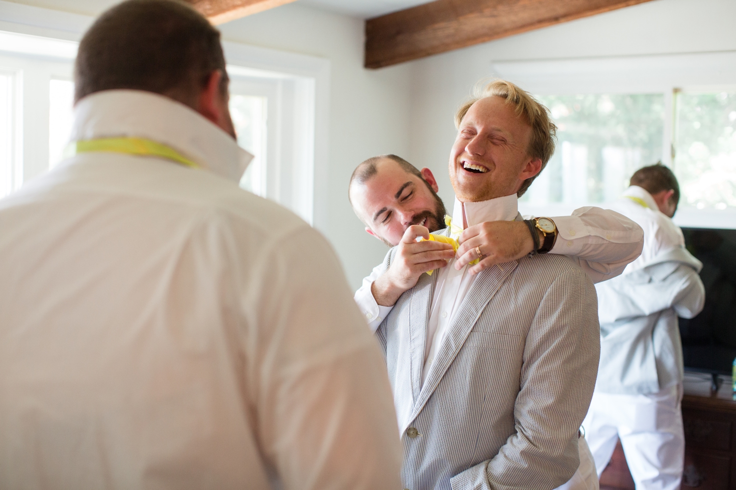 groomsman helps groom with his bowtie