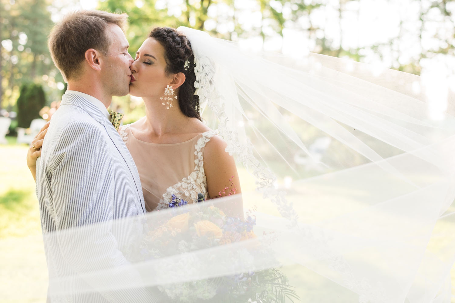 bride and groom kiss with wind-swept veil