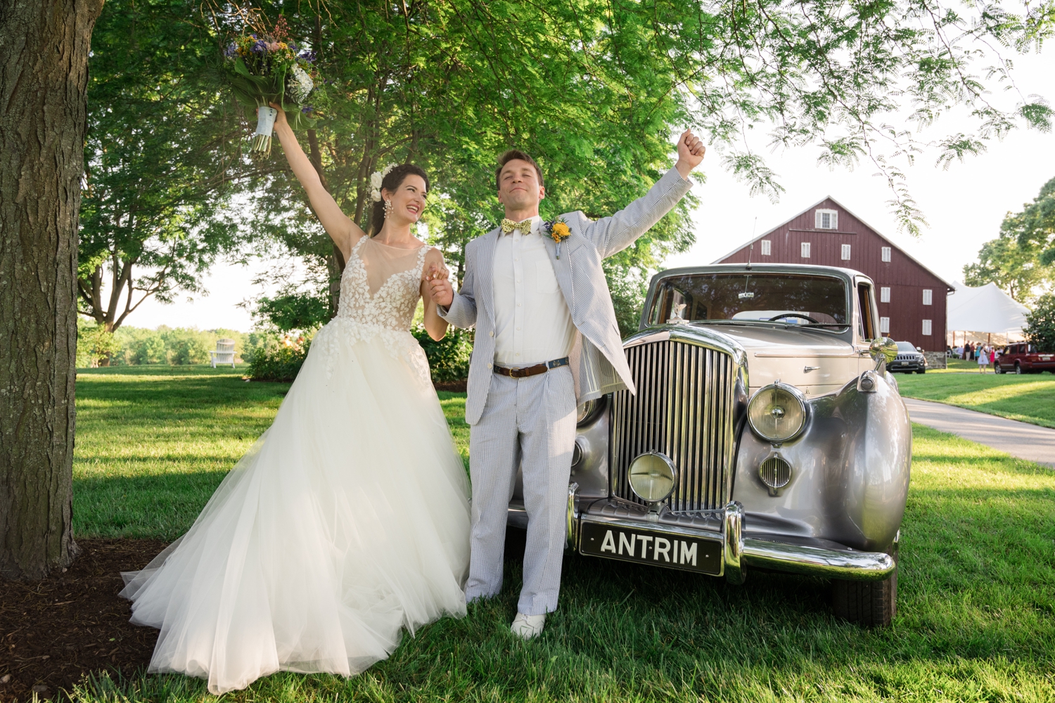 bride and groom celebrate by a vintage car