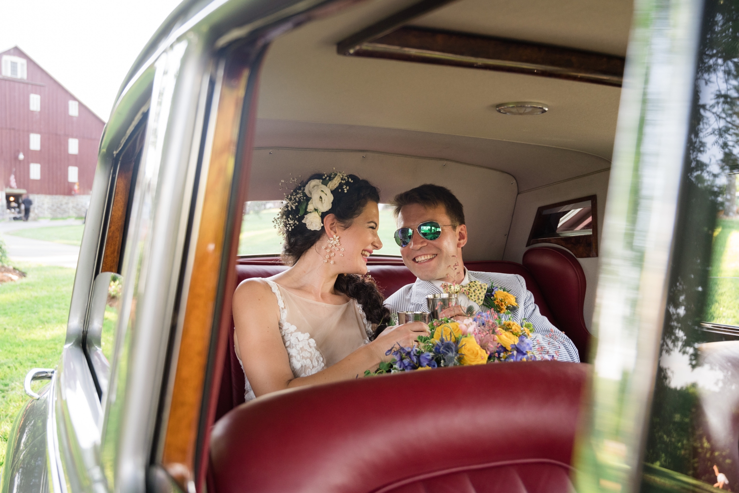 bride and groom make a toast in a vintage car