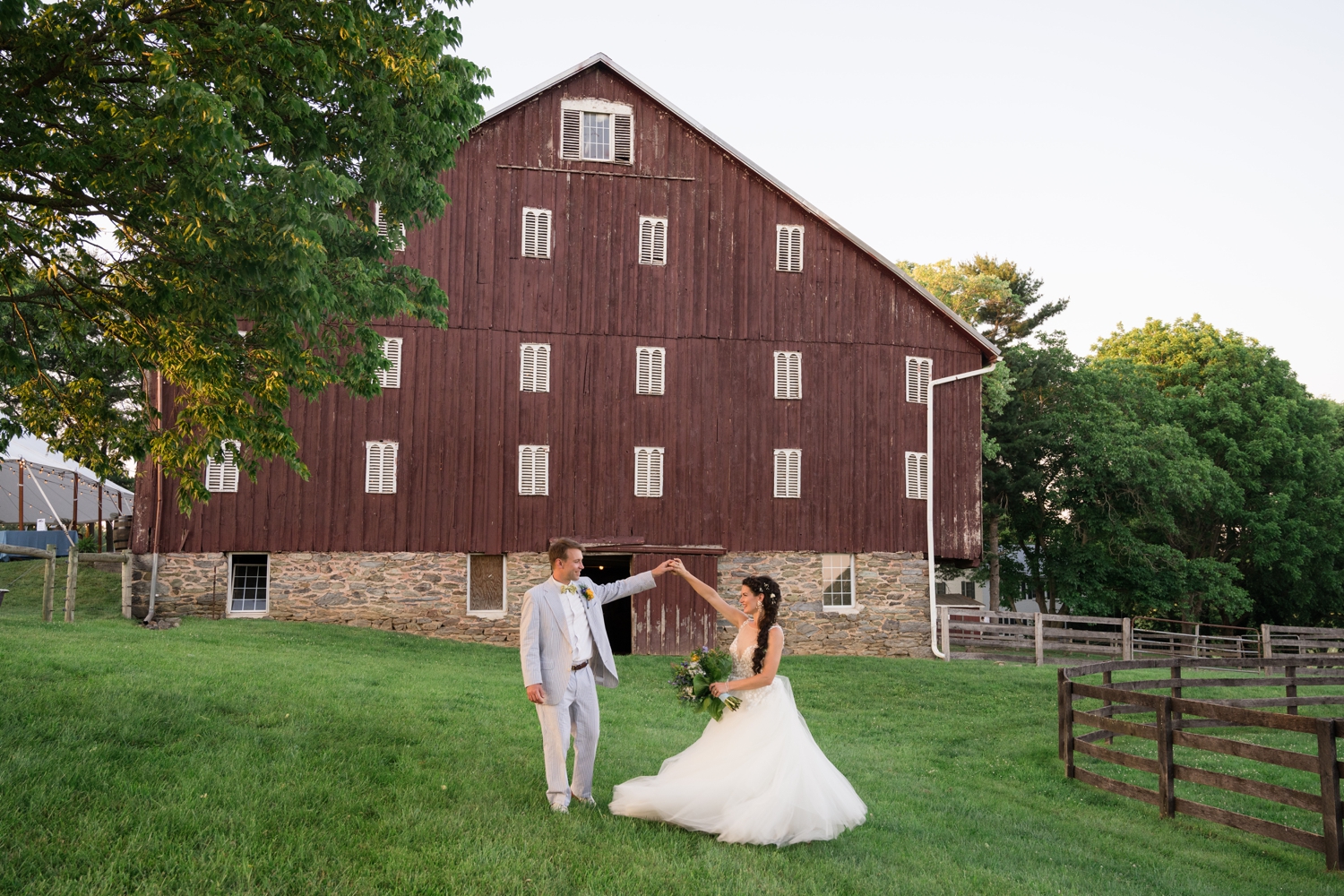 bride and groom dancing by the barn