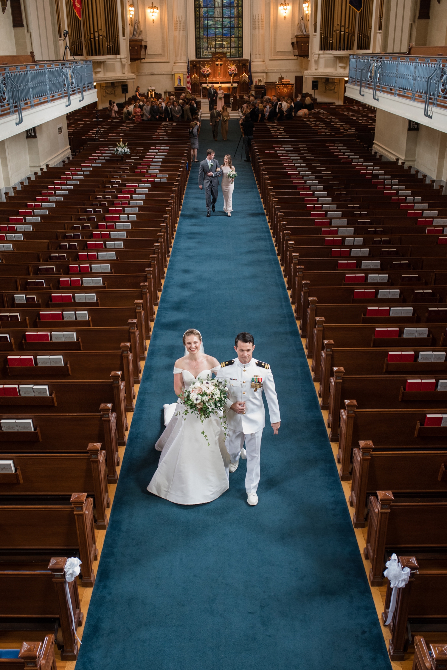 Shot from the balcony of the bride and groom walking down the aisle