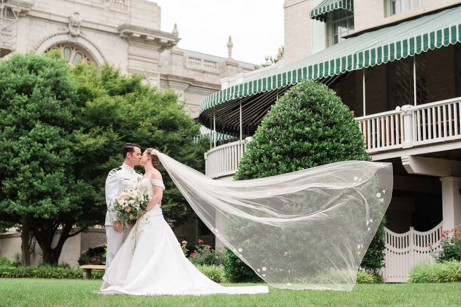 bride and groom kiss with wind-swept veil