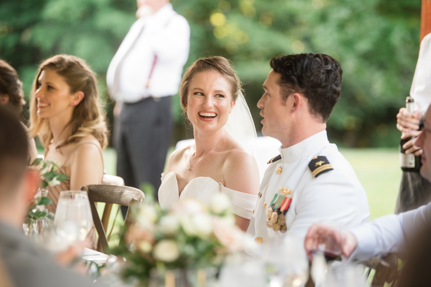 bride smiles at groom while sitting together during reception