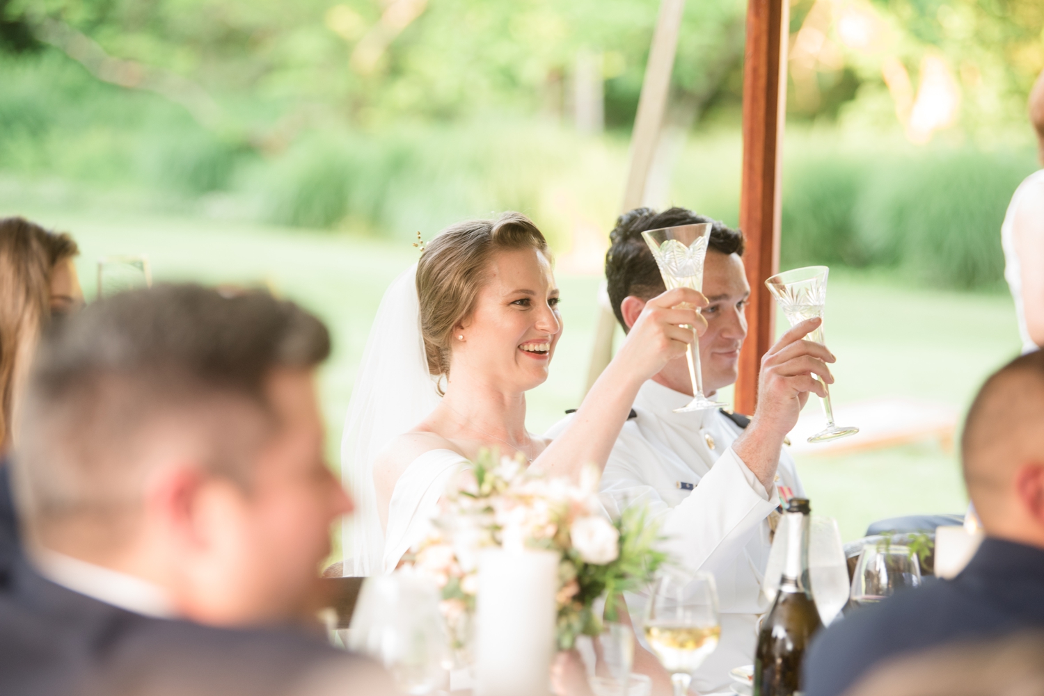 bride and groom raise their glasses for a toast with a smile