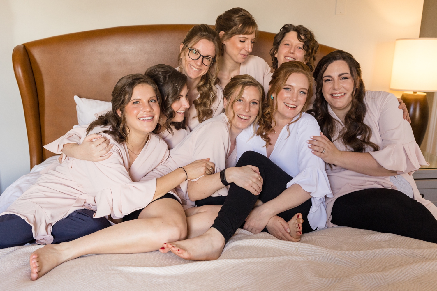 bridal party poses on the bed