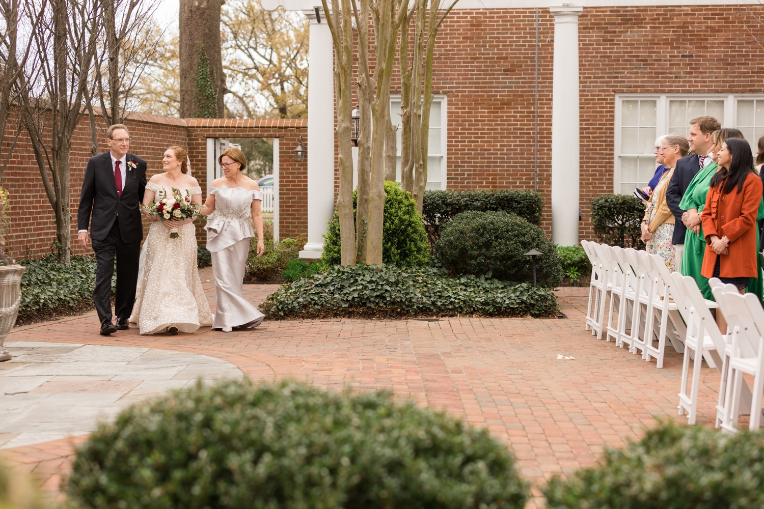 bride enters ceremony with parents