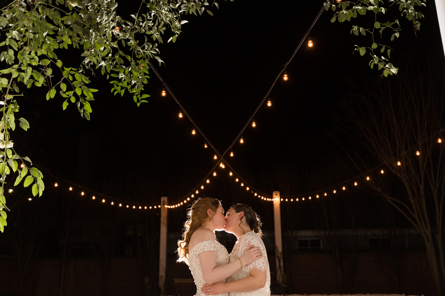 couple kisses under twinkly lights at the Tidewater Inn