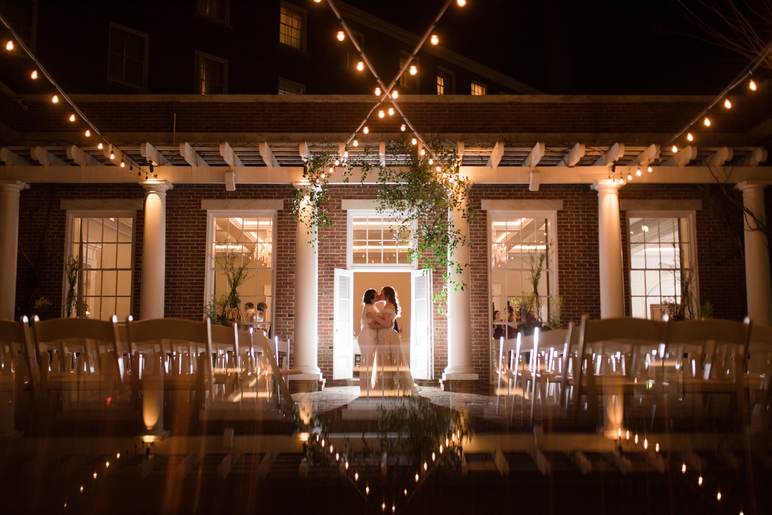 couple poses under twinkly lights at the Tidewater Inn