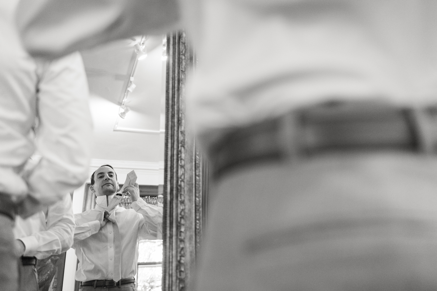 groom ties his tie at Hyatt Regency Bethesda