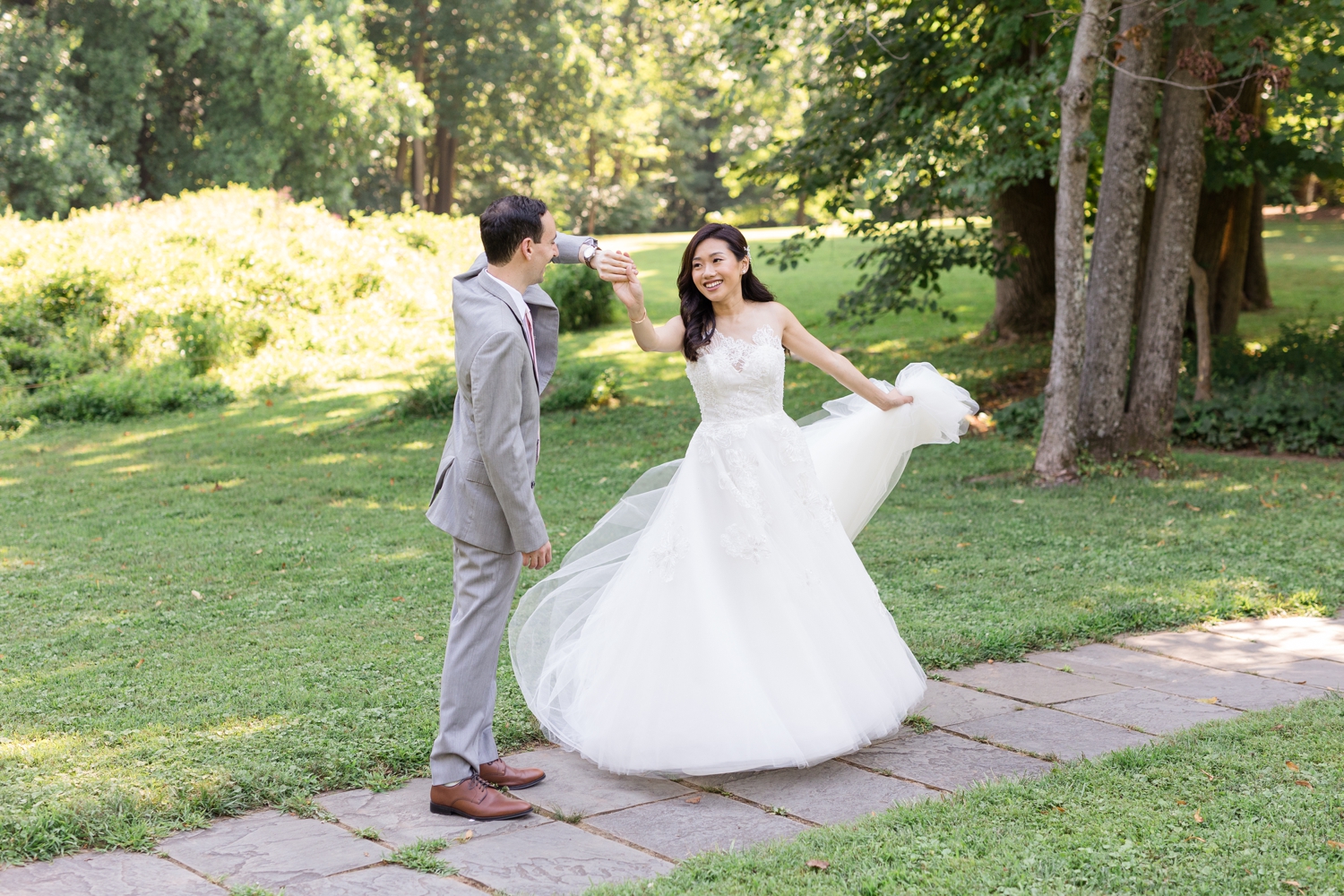 groom gives the bride a spin on the grounds at Woodend Sanctuary & Mansion 