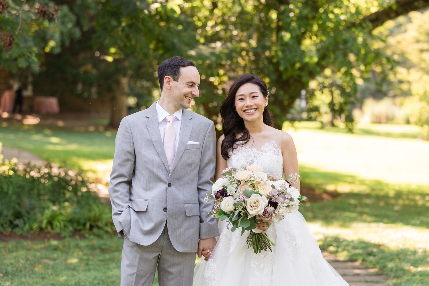 bride and groom smile and pose together on the grounds at Woodend Sanctuary & Mansion 