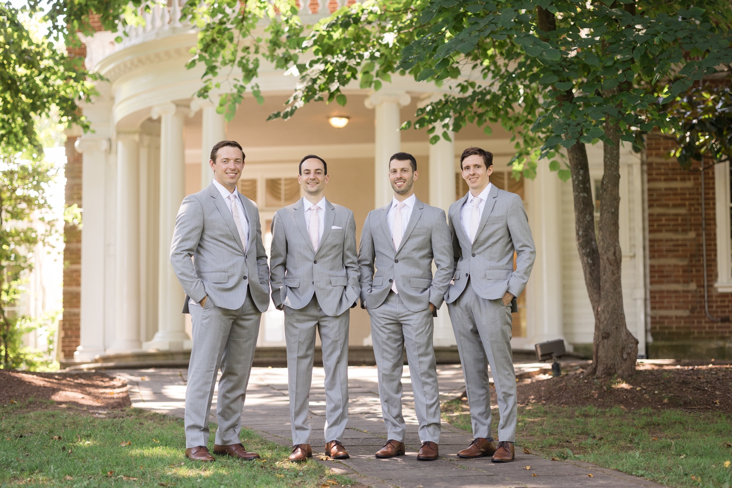 groom and his groomsmen pose on the grounds at Woodend Sanctuary & Mansion 