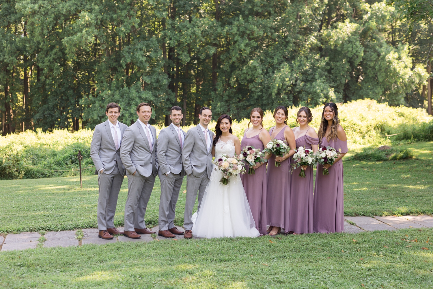 bridal party poses together on the grounds at Woodend Sanctuary & Mansion 