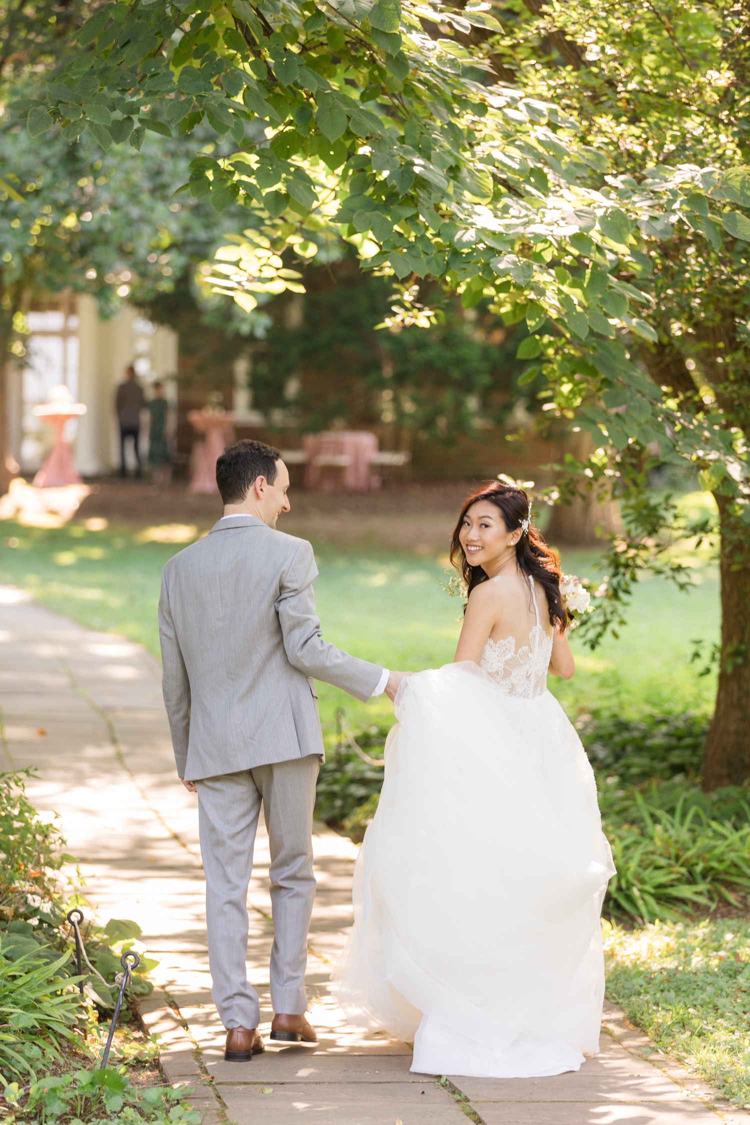 bride looks over her shoulder with groom at Woodend Sanctuary & Mansion 