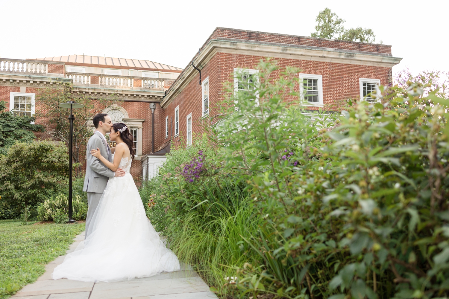 groom gives bride a kiss on the forehead on the grounds atWoodend Sanctuary & Mansion 