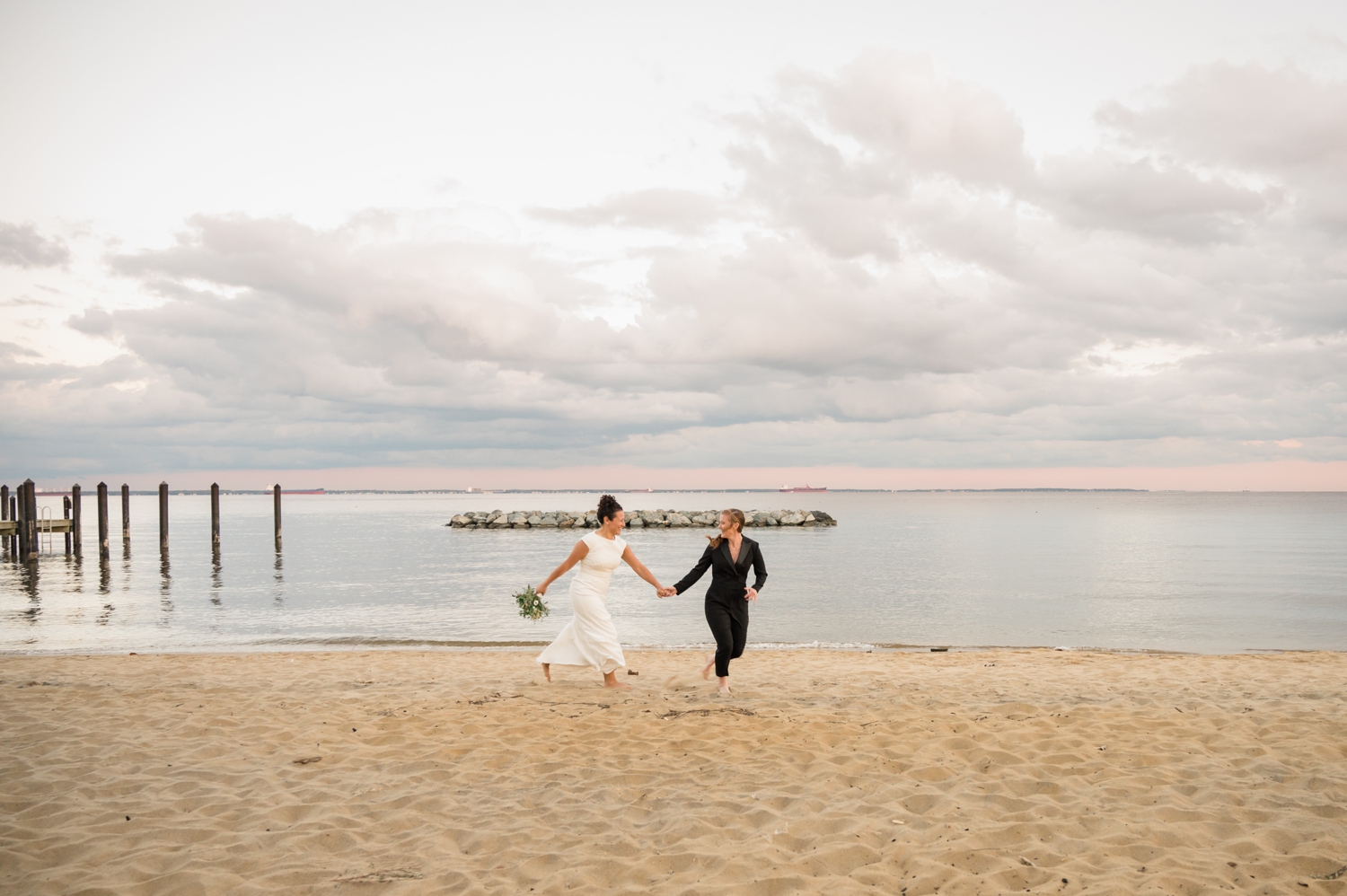 epic Chesapeake Bay Foundation beach wedding photos of couple in black jumper and white dress