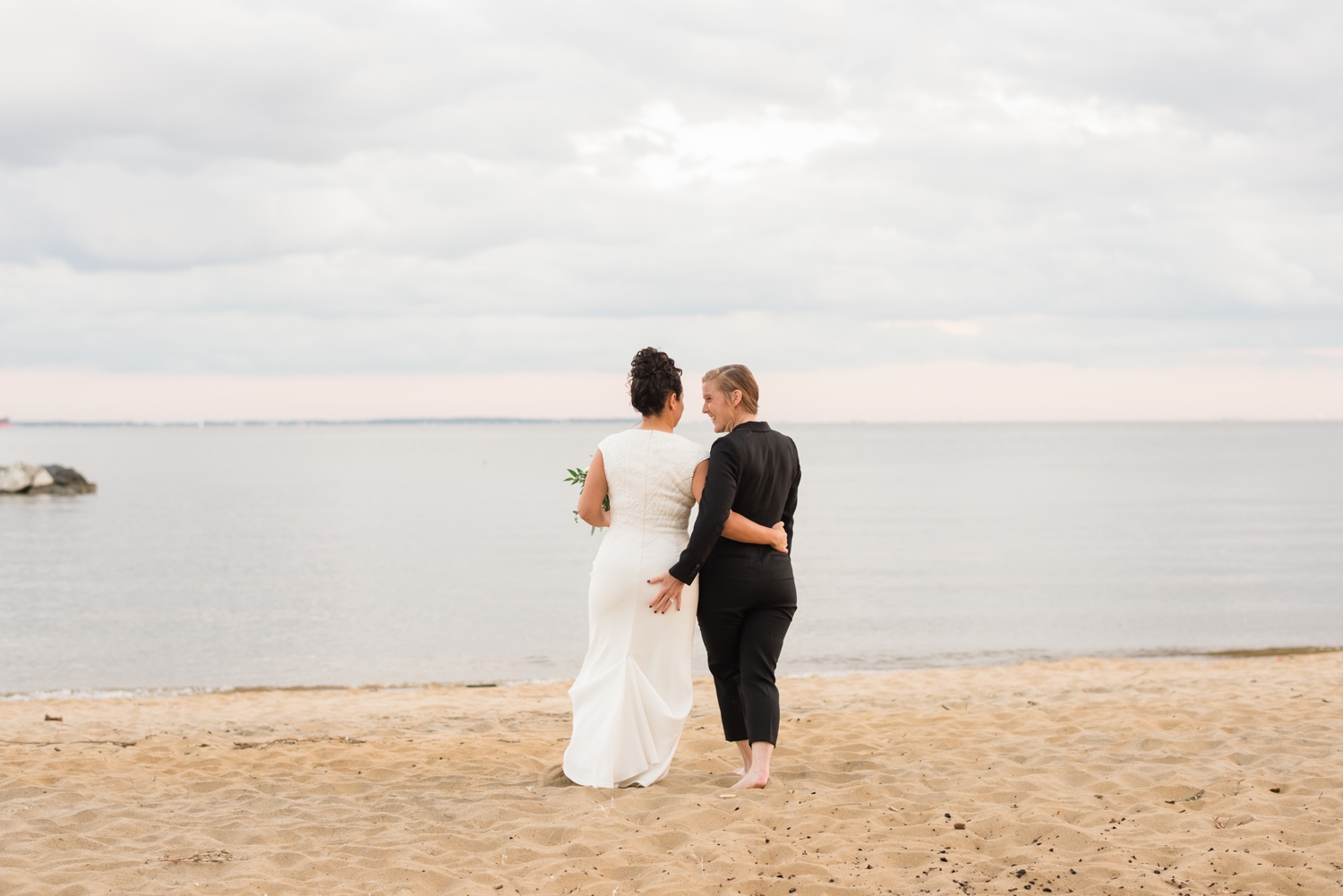 epic Chesapeake Bay Foundation beach wedding photos of couple in black jumper and white dress