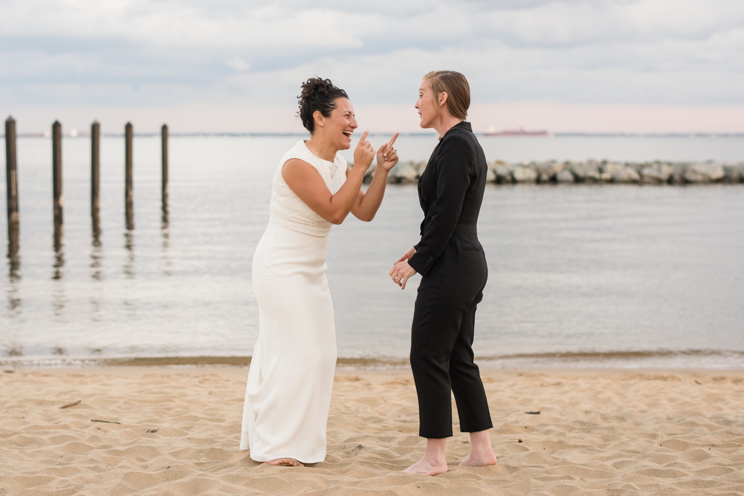 epic Chesapeake Bay Foundation beach wedding photos of couple in black jumper and white dress