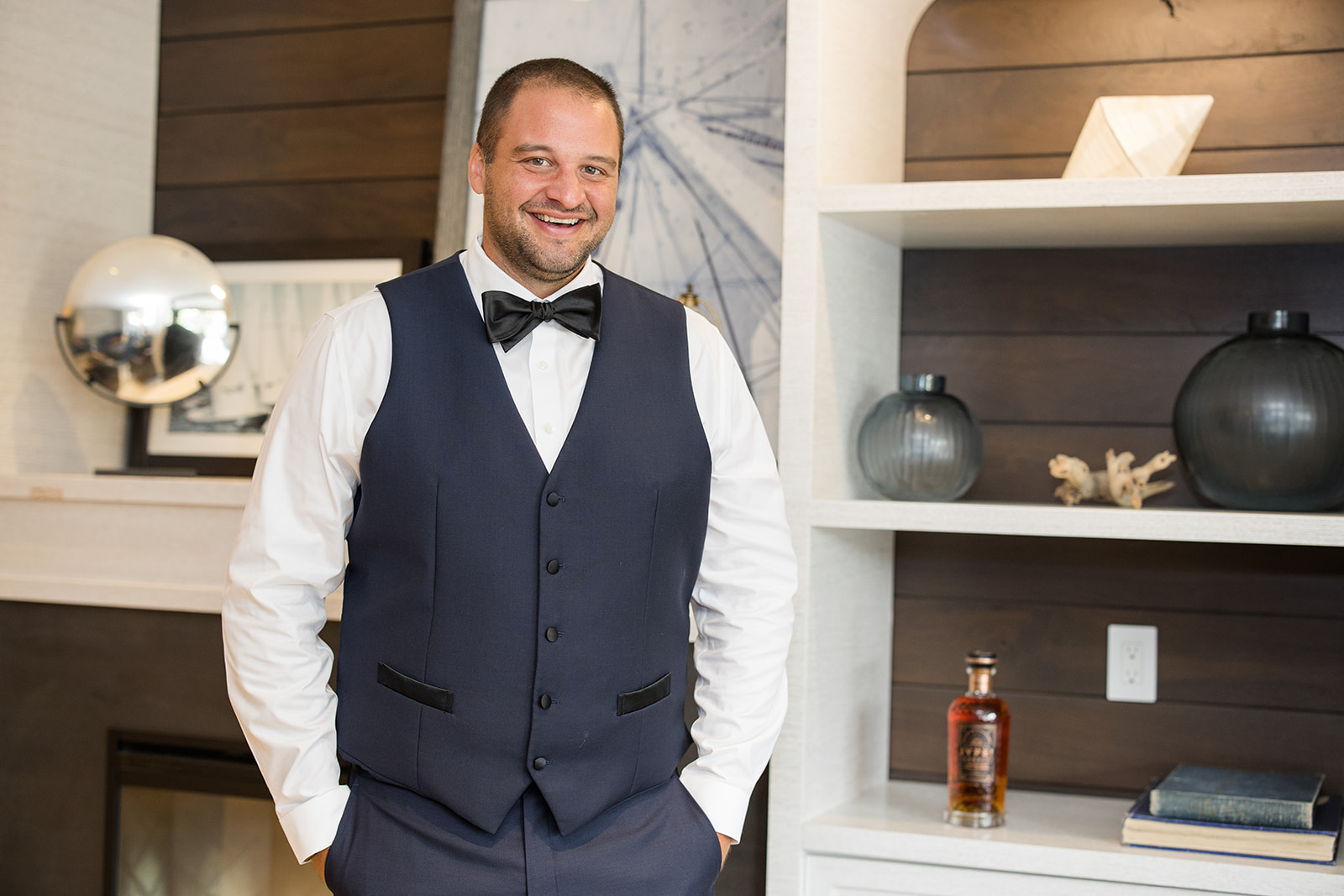 Groom portrait smiling at camera in vest and bow tie