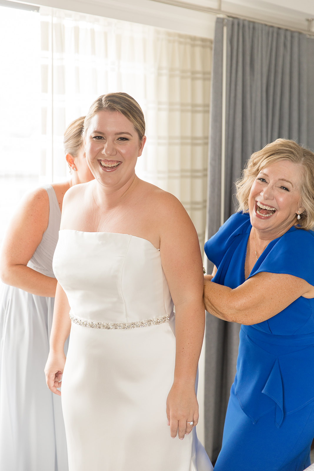 Bride's mother helps bride get dressed