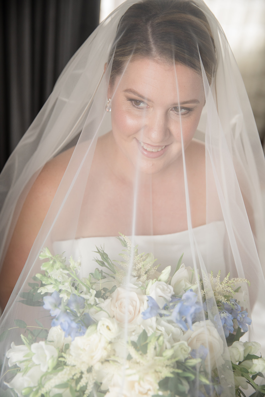 Bridal portrait with bouquet, veil over head