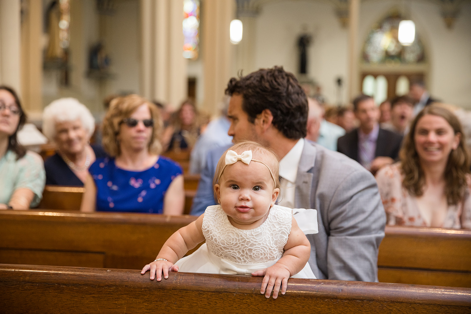 baby peeks over pew during wedding ceremony