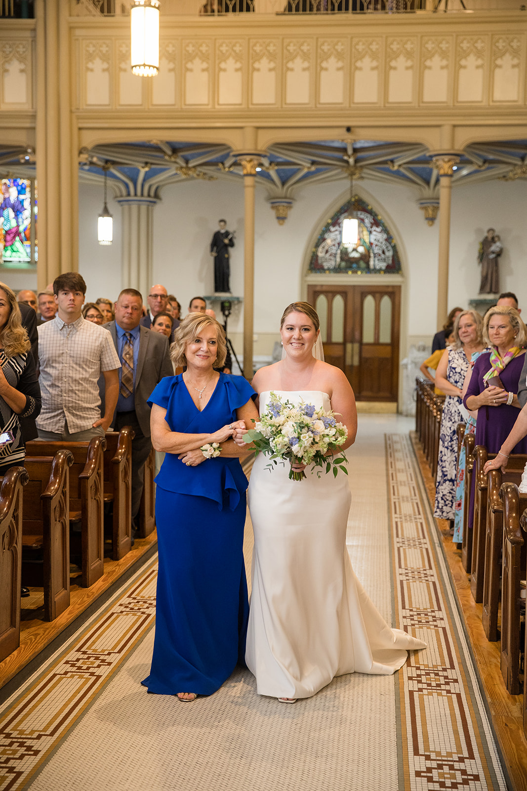 bride being walked down the aisle by her mother