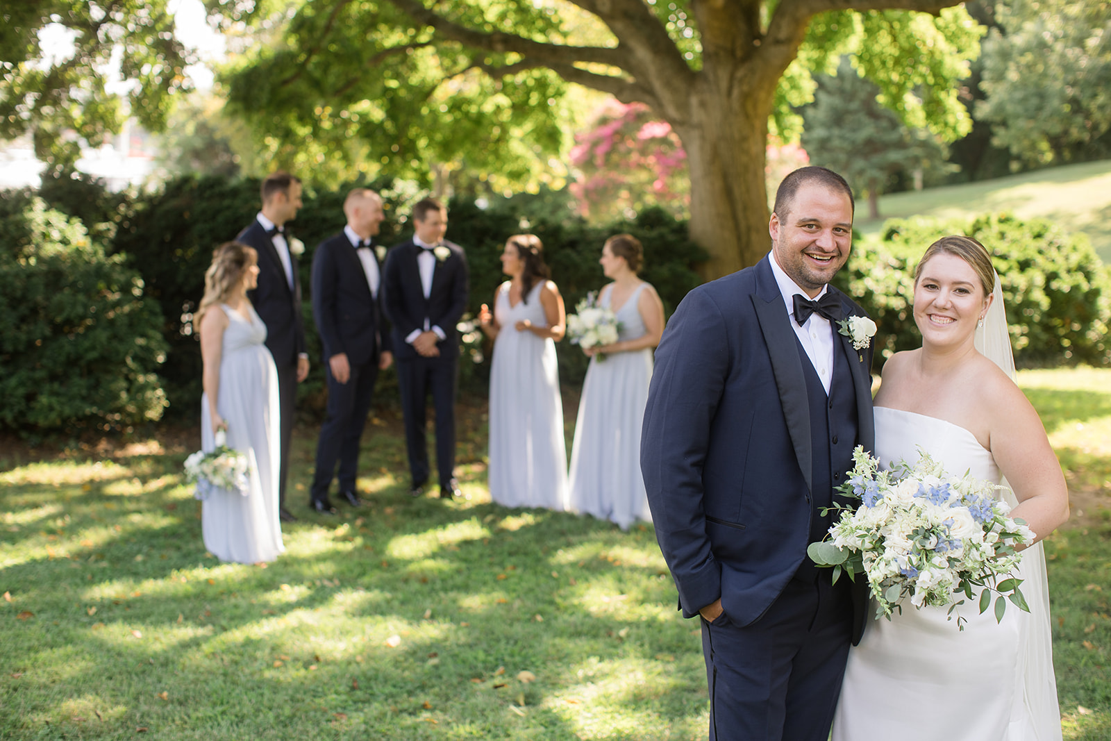 bride and groom in foreground with full wedding party behind them