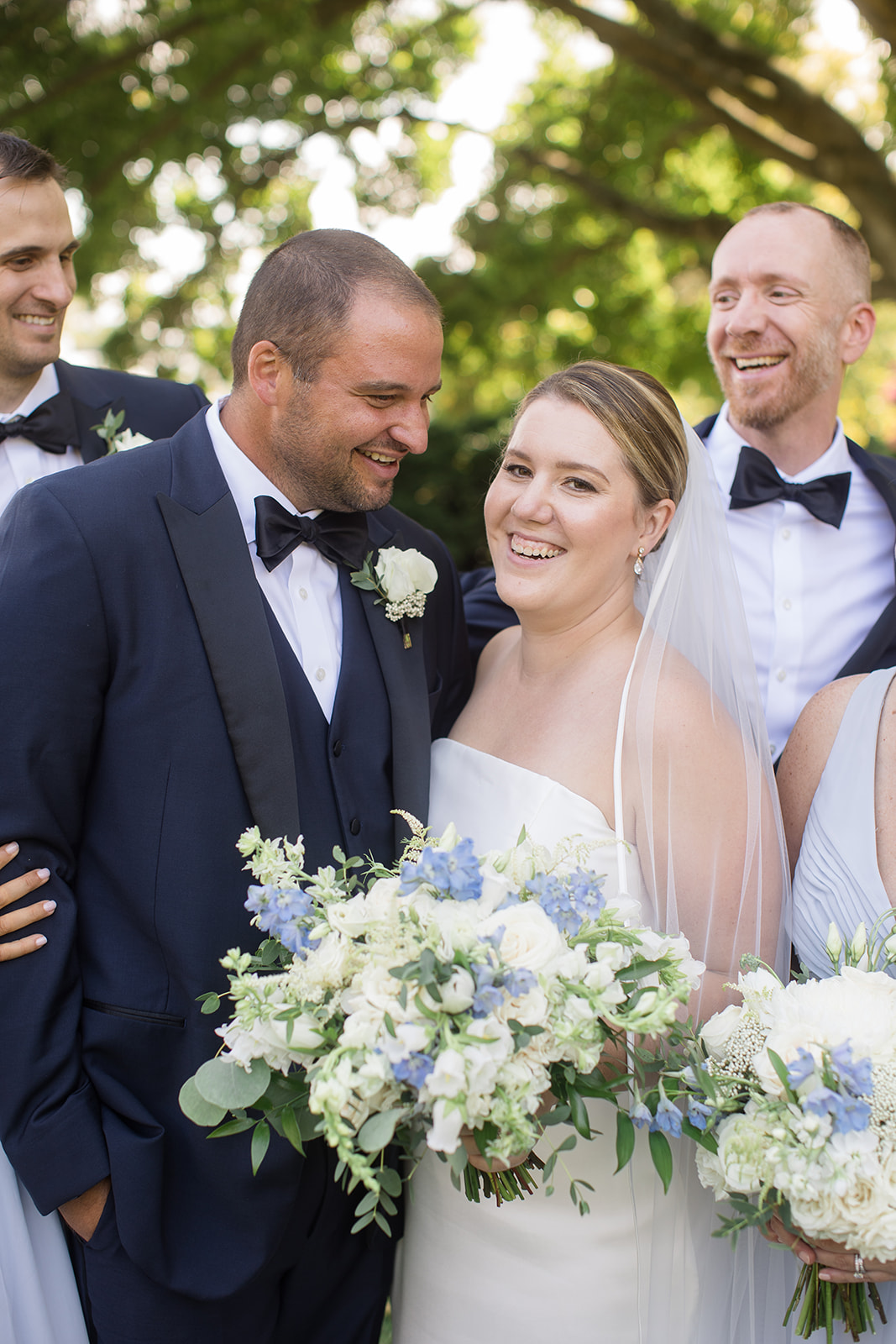 close up of bride and groom surrounded by wedding party