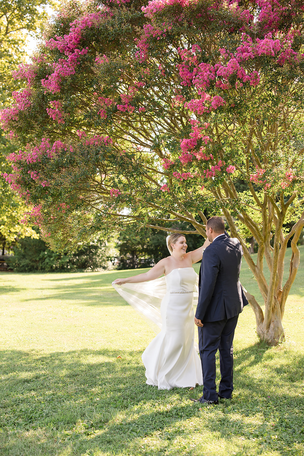 bride and groom portrait in grass under blooming tree