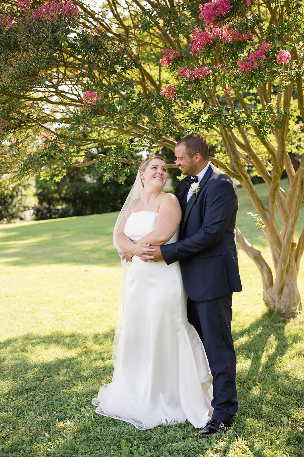 bride and groom portrait in grass under blooming tree