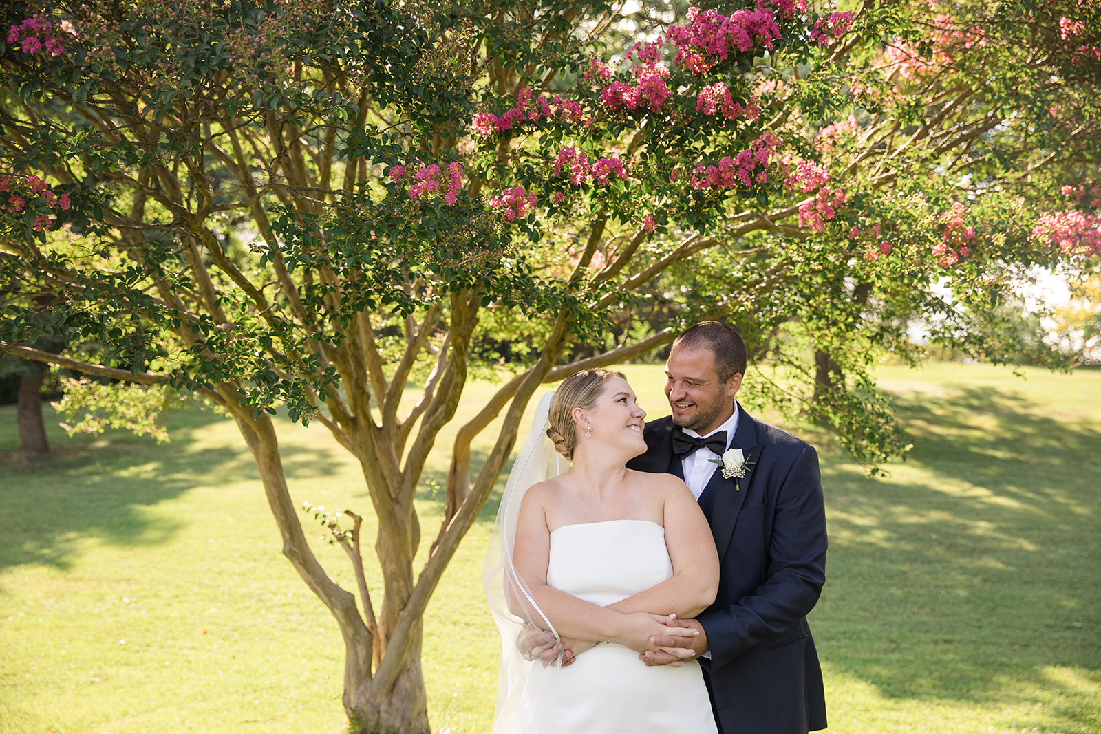 bride and groom portrait in grass under blooming tree