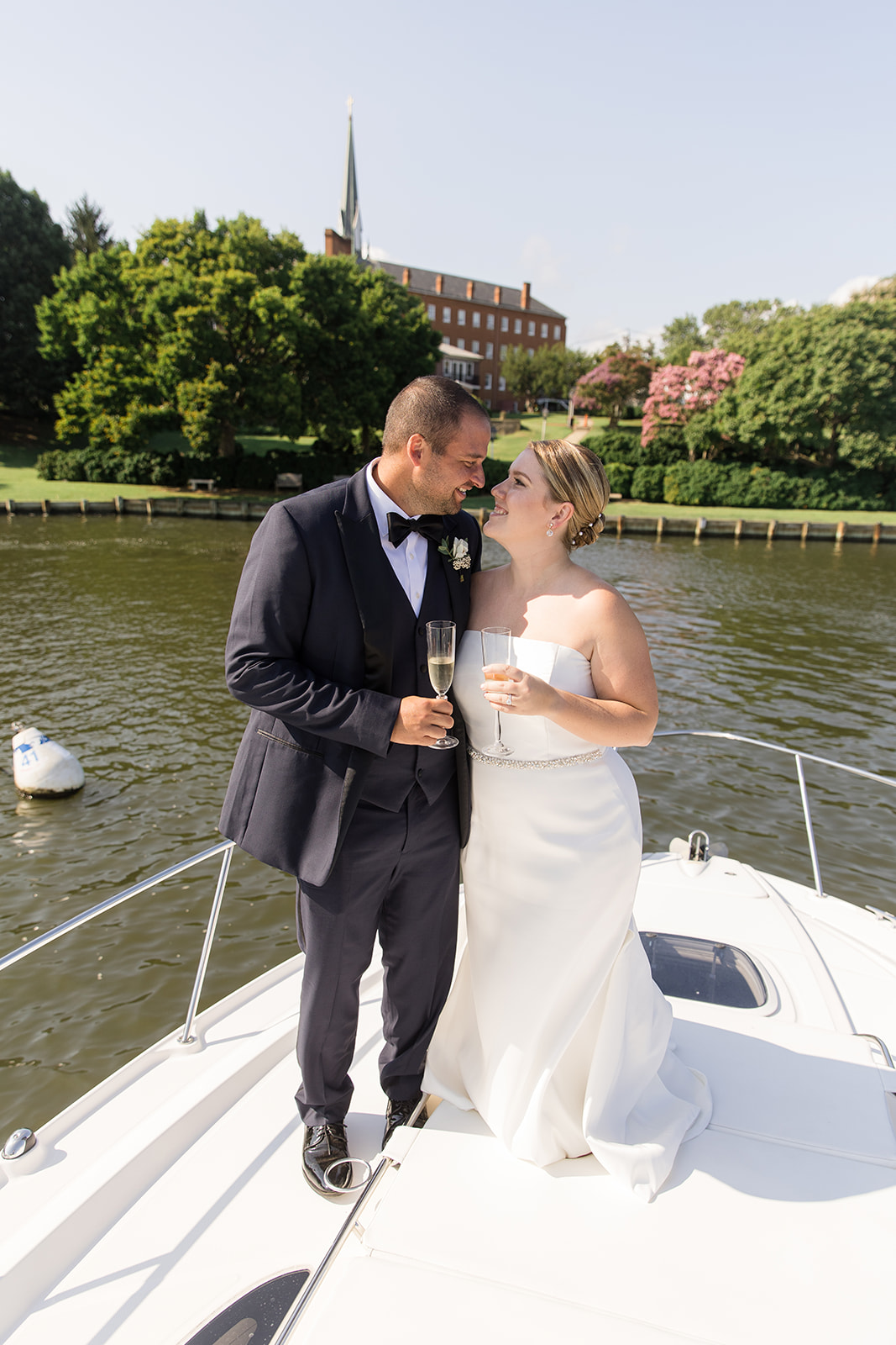 bride and groom looking at each other standing on bow of boat