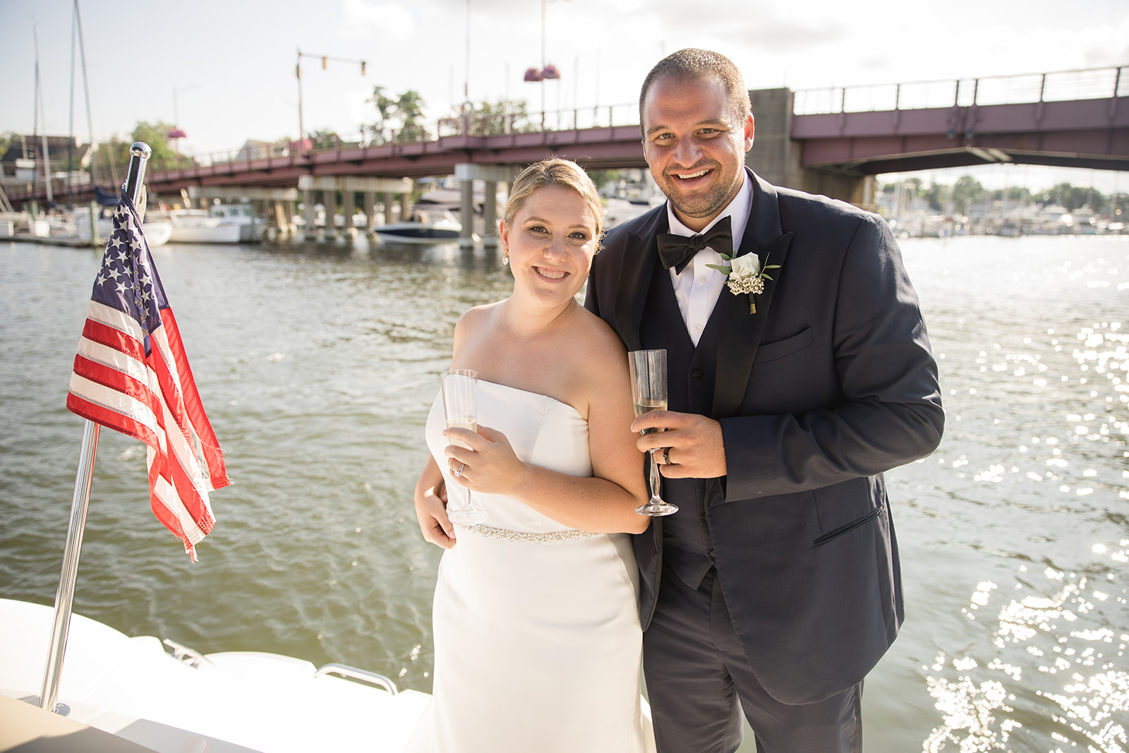 bride and groom holding champagne on boat